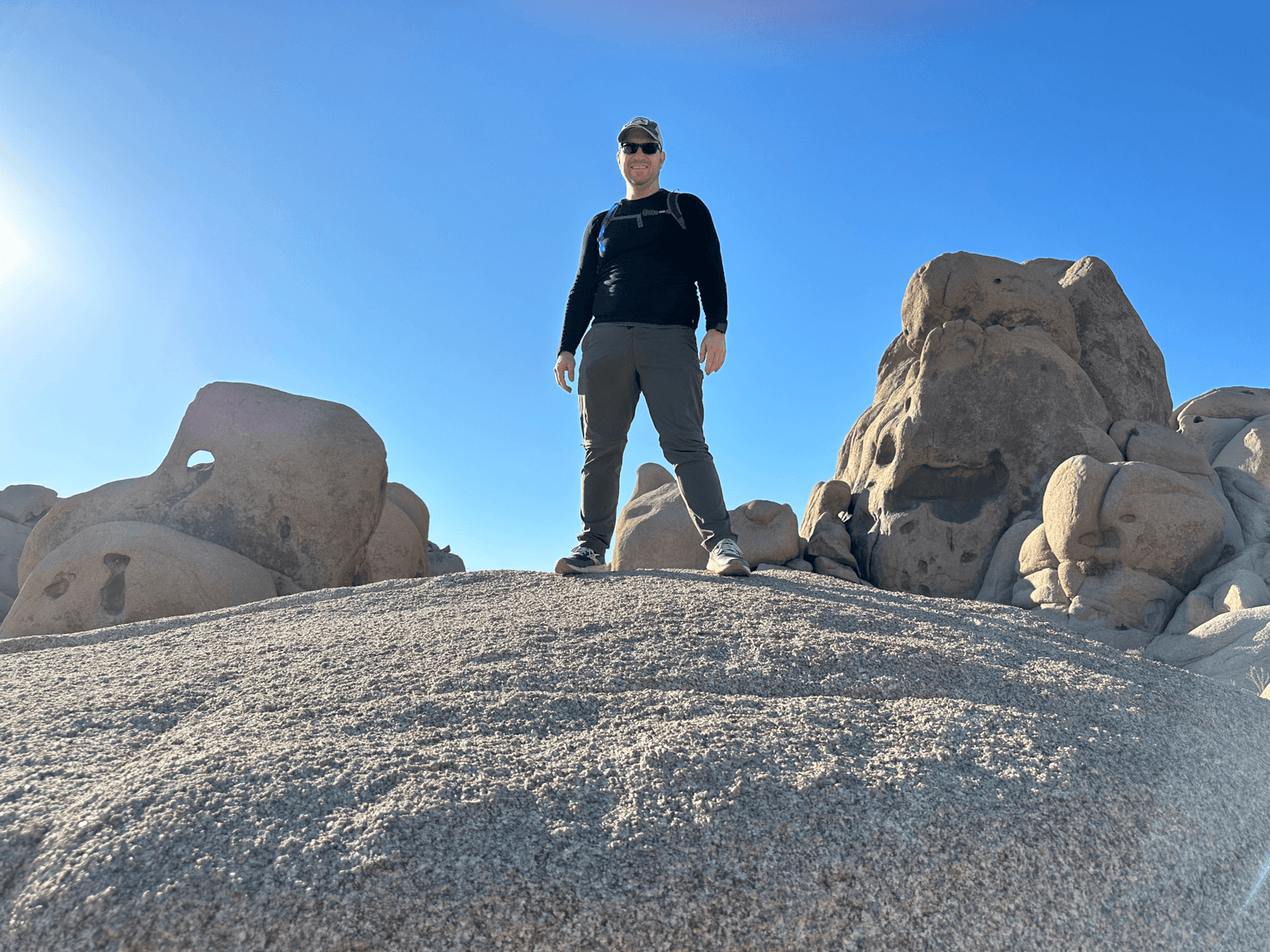 Josh Aversa stands on a boulder inside of Joshua Tree National Park